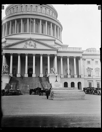 Getting ready for March 4. Already, in spite the slush and cold, workmen are busy on the plaza in front of the Capitol at Washington. Great piles of lumber for the stands are beginning to take shape