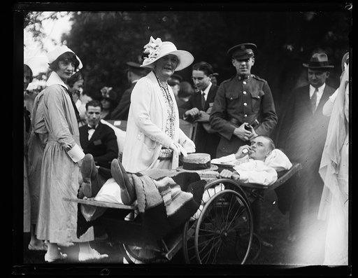 People gathered with wounded person in wheelchair