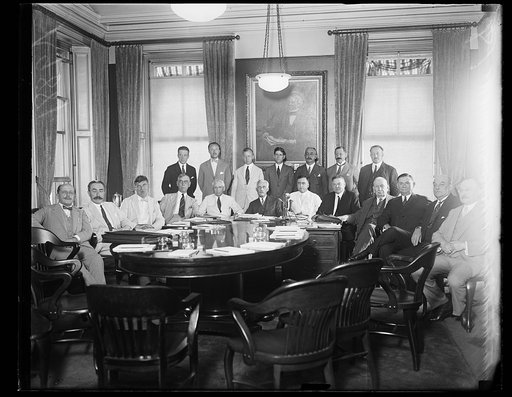 Group at table; includes Frank Kellogg, Andrew W. Mellon and Herbert Hoover