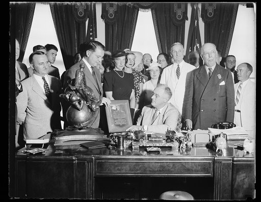 Franklin D. Roosevelt at desk with group and the Collier Trophy