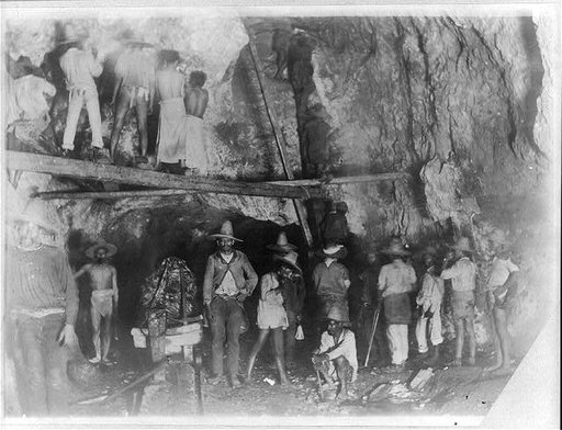 Interior of gold and silver mine in Mexico, showing various workers, tools, and operations