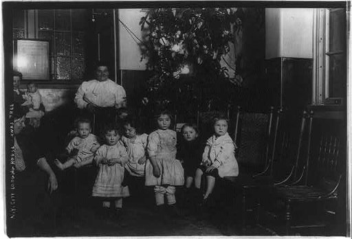 Small children in front of Christmas tree in New York City, lodging house