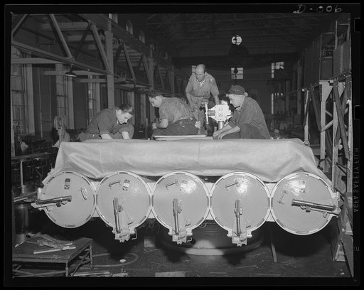 Finishing torpedo tube mount. Skilled workers in an eastern Navy yard arsenal putting the finishing touches on a torpedo tube mount. This arsenal is one of eleven working at top speed for the expanded war program of the Navy