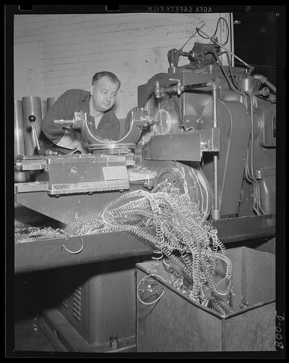 Brass shavings from cartridge cases. One of the last processes in making anti-aircraft cartridges is machining the head of the case. This worker in an eastern Navy yard is one of thousands who are producing ammunition for the expanded Navy war program
