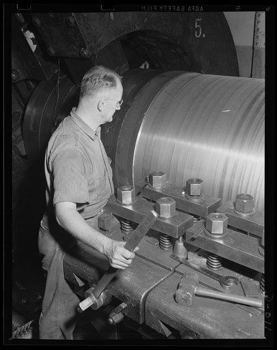 Turning one of the big guns. A skilled worker in an eastern Navy yard arsenal guiding the machine which is turning a major caliber gun. He is one of thousands who are producing ammunition for the expanded Navy war program