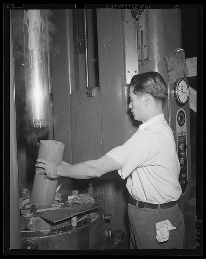 Drawing of a cartridge case. Skilled worker drawing a five-inch cartridge case for the big anti-aircraft guns. The yard in which the work is performed is one of eleven Navy yard arsenals which are working at top speed to furnish ammunition needed for our two-ocean Navy