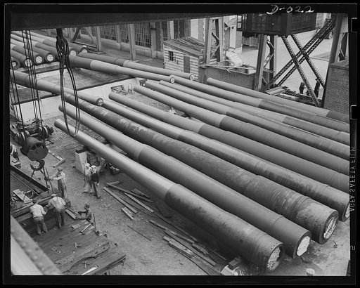 Tons of big guns for the Navy. Row of partly-finished guns in an eastern Navy yard. Heavy guns have to be shifted by overhead pulleys. This is part of the program to provide a two-ocean Navy
