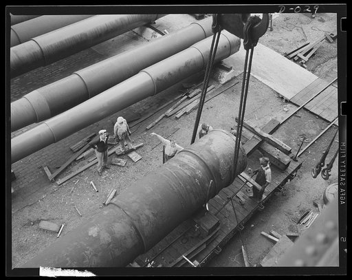 Heavy tonnage in Navy guns. Shifting the enormous guns in an eastern Navy yard required overhead pulleys and special flatcars. Guns are being produced in eleven Navy arsenals to arm the fleet of new warships for the new two-ocean fleet