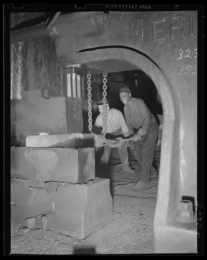 Mammoth weight of drop forger. Forging part of a large gun in an eastern Navy yard, one of eleven arsenals which have stepped up production to top speed for the war program
