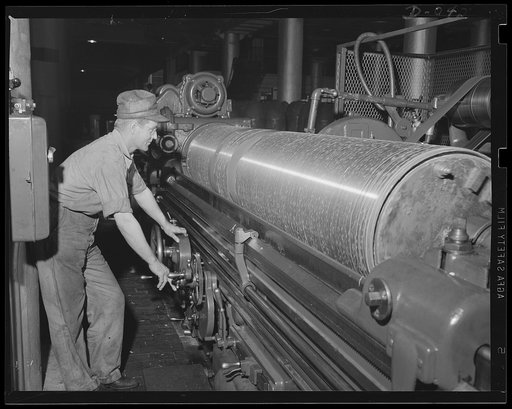 Forged steel to make the lungs of a torpedo. Smoothing down the outside of torpedo air flasks is this man's job. Production is going at top speed at the eastern Navy arsenal in which this equipment is produced