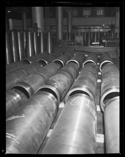 Teeth for a new destroyer. Partially-completed torpedo air flasks with "after bodies" in the background at an eastern Navy arsenal