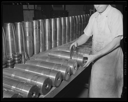 Gauging shells for big guns. New, shiny shells for the Army's 155 mm guns being gauged during production at a large eastern arsenal