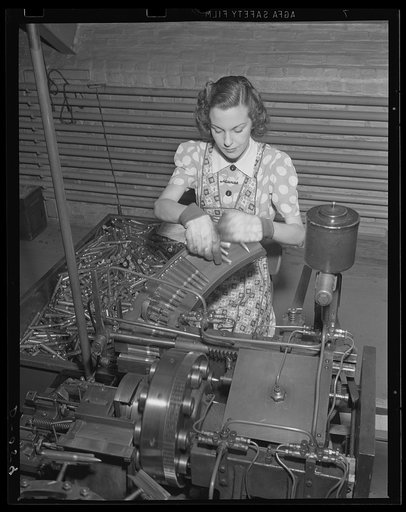 Fingers of destruction. Gauging and weighing 50-caliber ball cartridges in an endless row. Production for war is geared up to top speed at this eastern Army arsenal