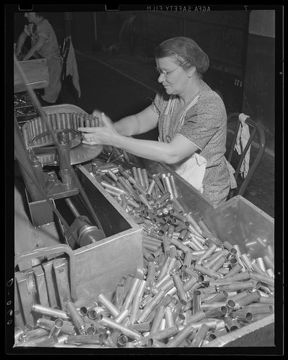 Feeding the modern machine. Skilled women as well as men are working on the country's armaments. These 50-caliber cartridge cases for guns are being tapered at a large eastern arsenal