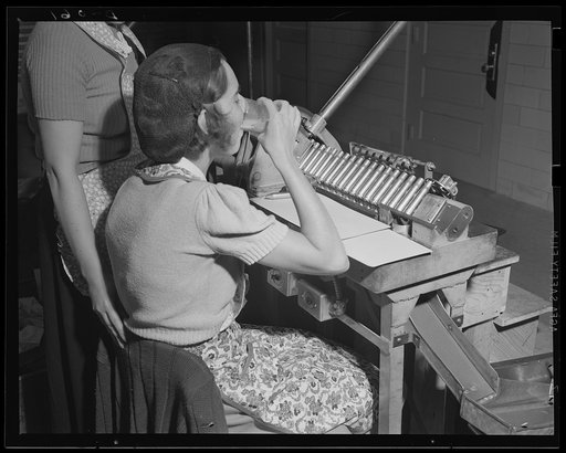 A breathing spell in the day's work. Girl in an eastern arsenal whose job is inspecting the 50-caliber catridges designed for anti-tank and anti-aircraft guns