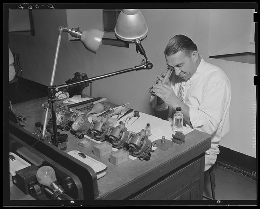 No errors, more hits. Expert opticians work on the optical assembly of aiming apparatus for the Army guns, produced at a large eastern arsenal