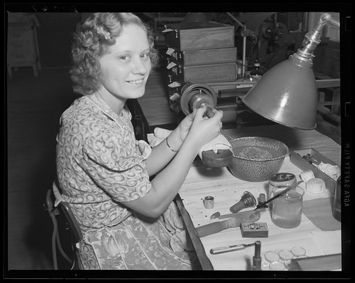 Making eyes for the army. Polishing lenses by hand in the optical department of an Army arsenal, where thousands of sights for guns are being turned out