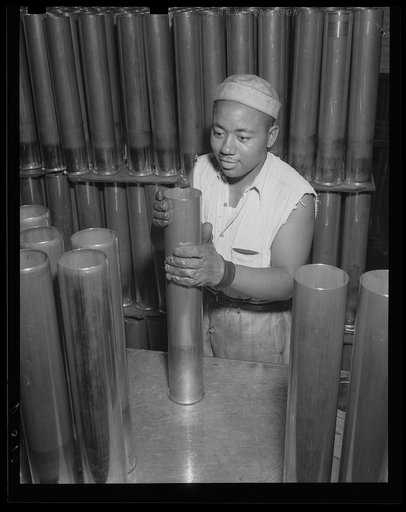 Individual attention for the big shells. Visual inspection during manufacture of shells for the Army's new guns. Thousands of these are coming down the production lines at a large eastern arsenal