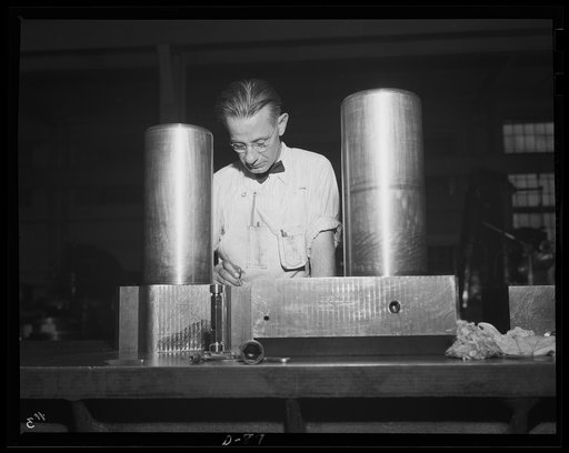 On the "assembly" line. Scores of parts go into Uncle Sam's big guns. Worker at a large eastern arsenal inspects some of the mechanism parts for medium-caliber guns. The utmost accuracy is required to ensure efficient performance