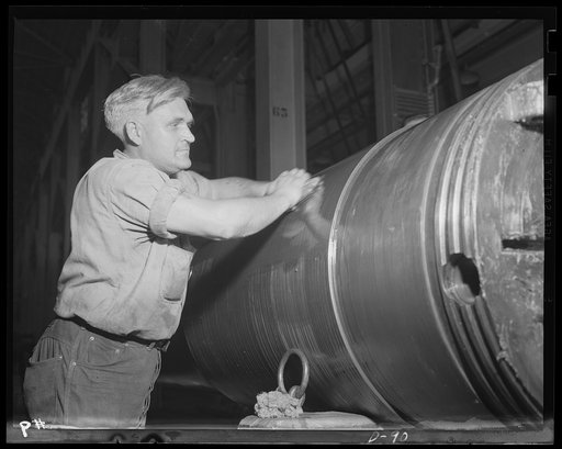 Polishing up a big one. Worker in a large eastern arsenal smoothing off one of the many big guns Uncle Sam needs for the war against the Axis