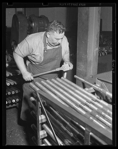 Ready for the next step. This workman is preparing a 50-caliber machine gun barrel for turning as war work preparation put work at an Eastern armory into high gear