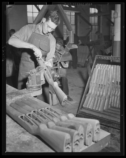 Out of the rough. A gun stock takes shape under the hands of a skilled workman as the war production goes ahead at an eastern armory