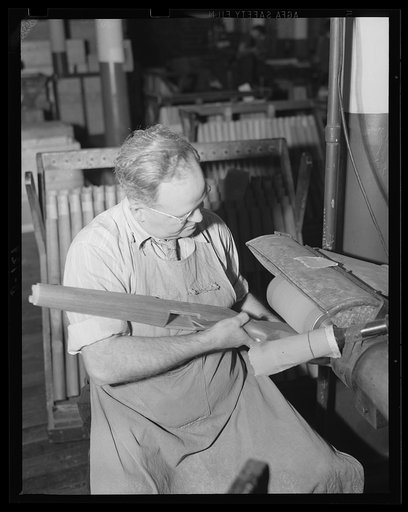 A fine finish is being given this gun stock on the sanding machine. One of the multitude of processes in the manufacture of rifles for the war program