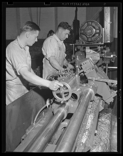 Turning out guns. Turning out guns on a modern automatic lathe. This machine is shaping the outside of a gun barrel for the war program
