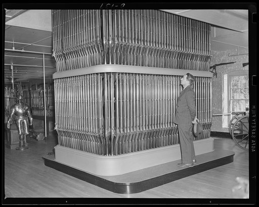 Organ of death. "This is the arsenal. From floor to ceiling, like a huge organ, rise the burnished arms." So wrote Longfellow in his poem, after seeing this stack of 1862 rifles. Now in another emergency the eastern armory again turns out guns for the war