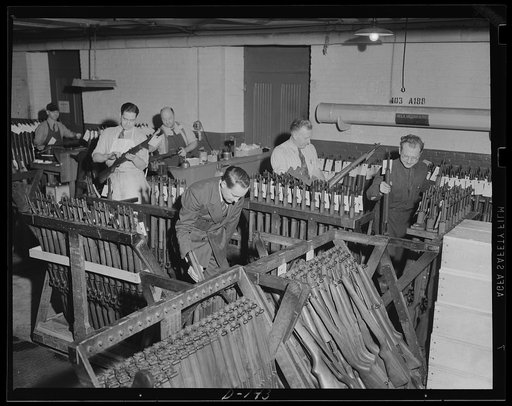 Putting them together. A corner of the assembly room at an armory, where war workers are putting together the parts which make up a Garand rifle