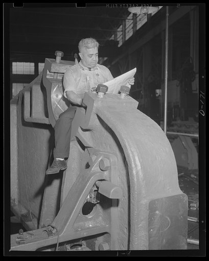 From paper to performance. One of thousands of blueprints is consulted in a check on assembly operations of a 16-inch gun, barbette carriage. The gun is being rushed for war work in an eastern arsenal