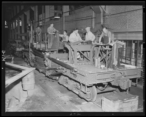 Ready for a payload. Inspectors check the assembly of a railway carriage which will soon carry an 8-inch gun. The guns are turned out in an eastern plant