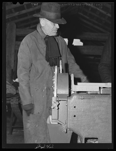 Shenandoah Valley. H.B. Alexander standing beside his corn stripping machine in his cannery at Port Republic, Virginia