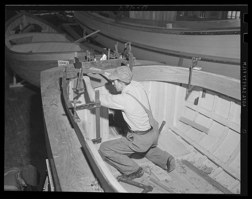 Trimming a fast one. A skilled workman fits the beading around the cockpit of a fast motor launch intended for the U.S. fleet. Boats of this type are being turned out rapidly at an eastern Navy yard