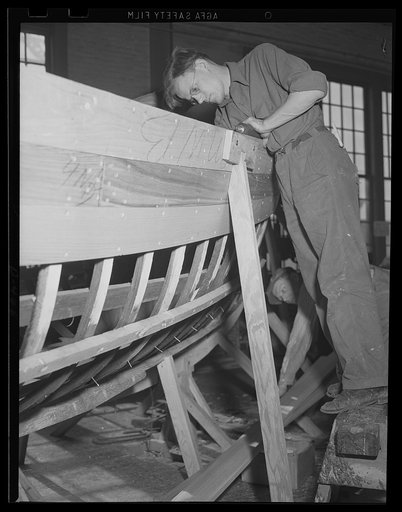 Little but tough. Skilled carpenters working on a 26-foot whaleboat, one of the small but necessary units to bring the two-ocean Navy up to full defensive strength. Work like this is being rushed at an eastern Navy yard