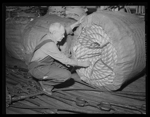 Another string saver. Uncle Sam needs lots of out-size cord for his Navy. Here at an eastern Navy yard manilla hawser is examined for defects before going into service