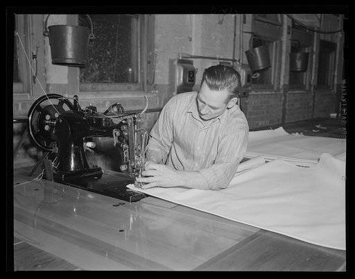 Very movable bunk. Making one of the many hammocks that will swing their human cargo below decks on Uncle Sam's ships at sea. Rush orders keep the sail loft busy at an eastern Navy yard