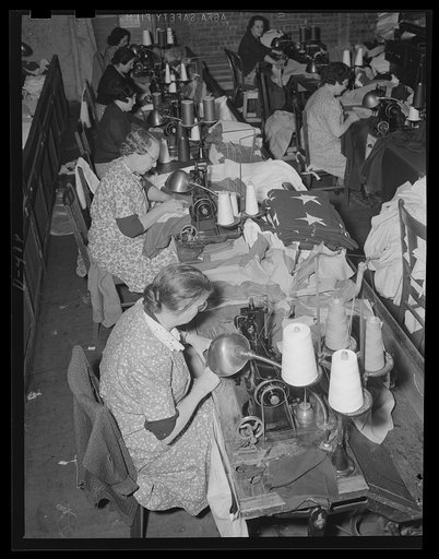 Betsy Ross 1941. Old Glory is turned out en masse by busy fingers at an eastern Navy yard. National and signal flags are needed in abundance for expanding Navy