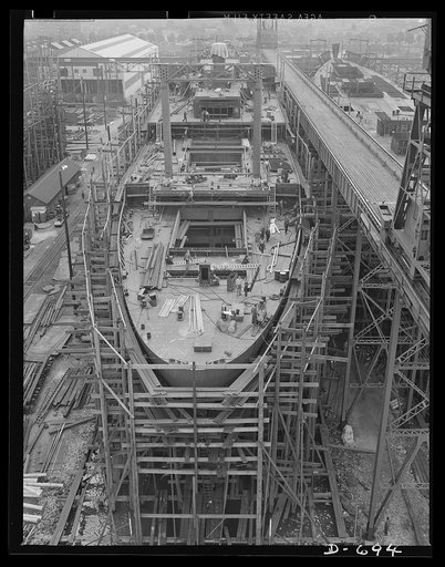 Newport News, Virginia. A C-3 passenger and cargo boat. The two tall posts in the middle are called "Samson posts" and are used to support derrick arms, cranes, etc, in loading and unloading the ship. They also serve as ventilators, as can be seen from the holes near their tops. The boat being built