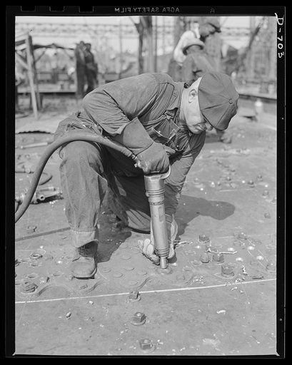 Newport News, Virginia. Riveter installing button-head rivets in a deck fitting of a C-3