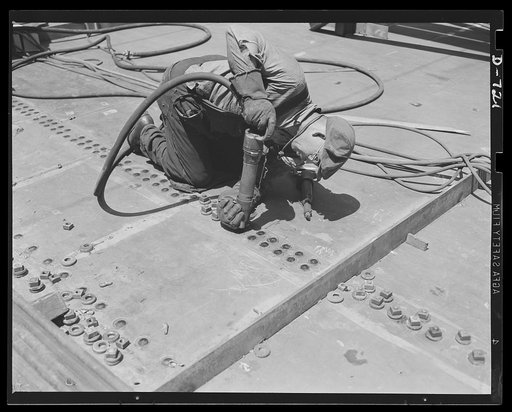 Newport News, Virginia. Riveter at work on the plates of a deck section of a C-3