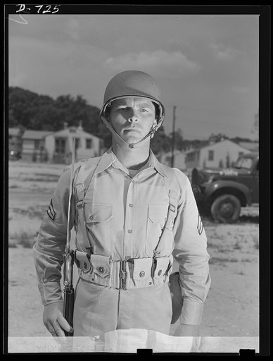 New Army helmet. Corporal French L. Vineyard, Company M, 12th Infantry, wearing a new Army helmet. Corporal Vineyard is wearing the combat pack and cartridge belt and is equipped with a Garand rifle with bayonet affixed