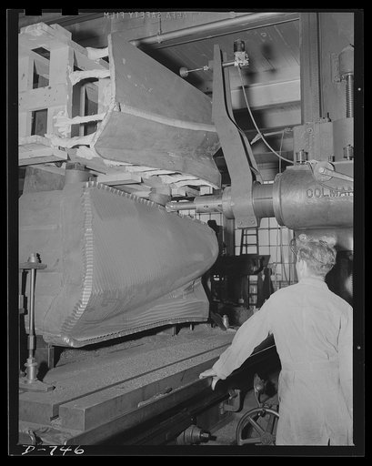 A Keller machine cutting a die shape from a plaster model. The plaster model is at the top. A "feeler" tool runs along the surface of the model and controls the cutting tool at the bottom in such a manner that the contours of the model are duplicated with an extremely high degree of precision on the