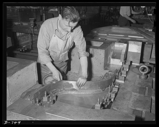 A die maker checking joints of a trim and pierce die which will be used to stamp out parts of automobile fenders. Photo made at Frederick Colman & Sons, Inc., Detroit, Michigan