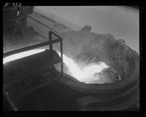Close view of a ladle being filled. After filling, the ladle is taken either to the open hearth foundry or pig casting house. Location: in a large easten steel plant