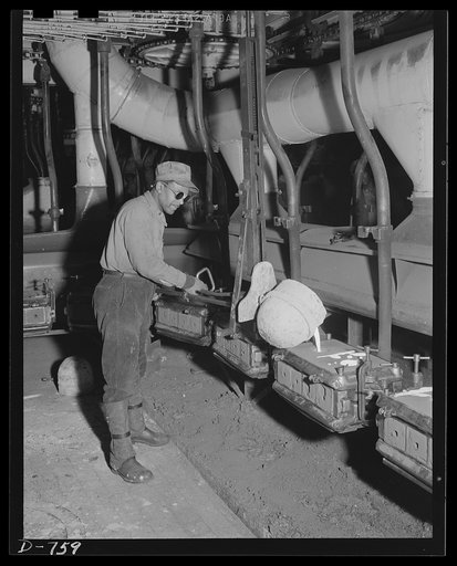 A scene in the Ford foundry, Detroit, Michigan. The foundry covers seventeen acres of land. Twenty-five tons of molten metal can be poured here every twenty-four hours. Worker in this photo is filling piston moulds. Twenty thousand pistons are cast every eight hours
