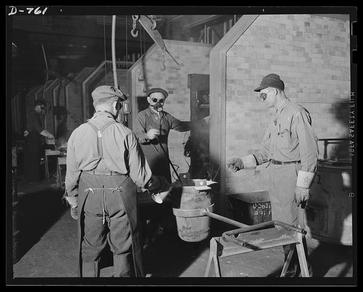 Workmen checking the temperature of magnesium alloy and "salting" the mixture (i.e., adding chemical necessary to the particular alloy combination at hand) before pouring it into the moulds. Ford River Rouge Foundry