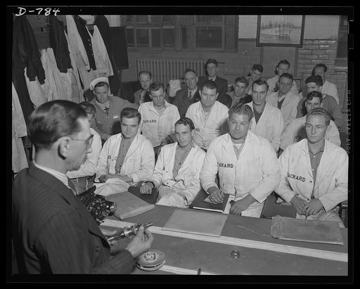 An instruction class at the Packard marine engine plant in Detroit. The students attending the class shown here are Navy cadets