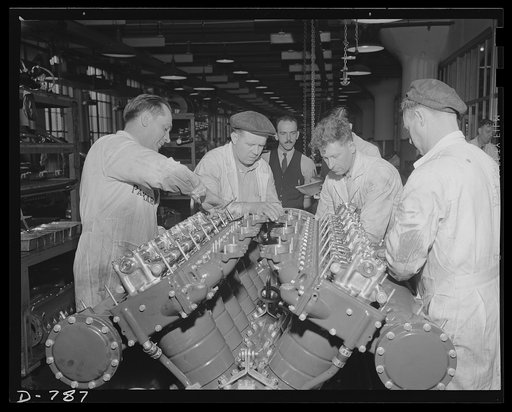 Machinists assembling the super-charger to a marine engine. Packard marine engine plant