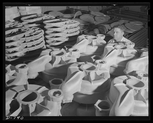 Storage of rough stock at the Packard marine engine plant, Detroit, Michigan. Photo shows, in foreground, super-charger impeller casings. In the left background are large aluminum super-charger gear housing. The right background shows a pile of steel reverse gear crankshaft flanges